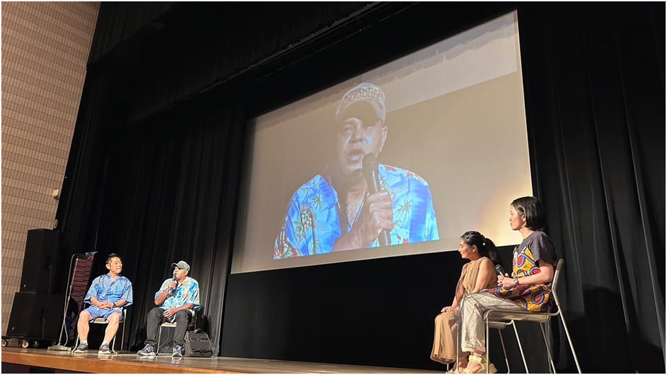 難民が舞台に立って講演を行っている様子