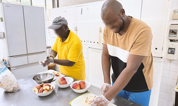 難民の男性二人が料理を行っている様子